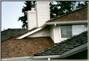 This is a great photograph depicting the differences between a "treated" roof and an "untreated" roof after two years since construction of all three roofs.